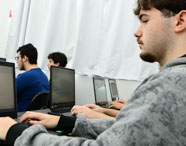Aluno da Unoeste realizando atividades práticas com notebook durante aula. 