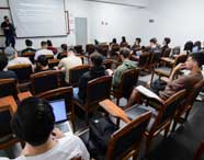 Professor apresenta sobre transformação digital para alunos da faculdade de Ciência da Computação em sala de aula, abordando conceitos de tecnologia e inovação em empresas.