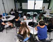 Alunos de Ciência da Computação engajados em aula com metodologias ativas, participando de discussões em grupo e aprendizado colaborativo em sala.