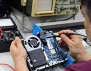 Especialista de Análise e Desenvolvimento de Sistemas realizando manutenção e testes em hardware de mini computador em laboratório de arquitetura, utilizando equipamentos de medição.