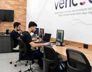 "Desenvolvedores de software do curso de Análise e Desenvolvimento de Sistemas trabalhando na ""sala de talentos"" da empresa Vericode, focados em projetos de TI e desenvolvimento de soluções.  "