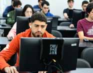 Faculdade de Análise e Desenvolvimento de Sistemas: alunos do campus de Presidente Prudente participam de atividade prática em laboratório de informática. A imagem valoriza o engajamento e a diversidade do grupo, demonstrando a integração dos estudantes com as tecnologias e as demandas do mercado de TI.