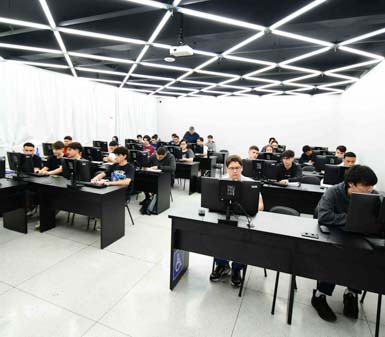 Análise e Desenvolvimento de Sistemas Unoeste: alunos no laboratório de informática do campus Presidente Prudente, utilizando computadores para atividades práticas de programação e desenvolvimento de software. O ambiente moderno destaca a infraestrutura e a preparação tecnológica do curso.