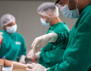 Estudantes da Unoeste realizando procedimento prático de enfermagem com supervisão em ambiente laboratorial. 
