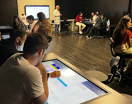 Alunos da Faculdade de Nutrição em Guarujá participando de aula em sala moderna com recursos tecnológicos.