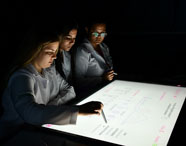 Estudantes da Unoeste em atividade com mesa digital na sala Betha do campus Guarujá. 