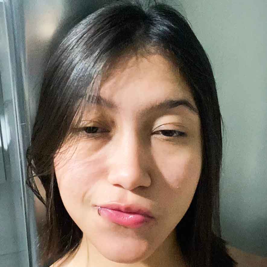 Lívia, aluna de Educação Física - Bacharelado, posando em um ambiente interno com um fundo claro. Ela tem cabelos longos e lisos, e usa um piercing no lábio, com uma expressão neutra.