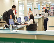 Estudantes acessando a biblioteca da Unoeste Guarujá, com estrutura moderna e ambiente de estudo. 