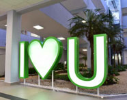 Letreiro I love U na entrada do campus Unoeste Guarujá, com prédio institucional ao fundo. 