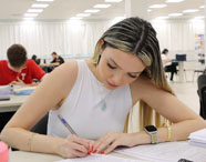 Estudante da Faculdade de Nutrição de Jaú concentrada em tarefa acadêmica individual.
