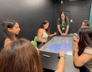 Alunos da Faculdade de Nutrição de Jaú utilizando mesa interativa na Sala Betha durante aula prática.