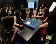 Alunos da Psicologia utilizando mesa interativa na Sala Betha, com foco em tecnologia educacional.