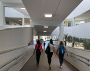 Alunos da Unoeste Jaú caminhando por corredor coberto no campus, em ambiente moderno e acolhedor. 