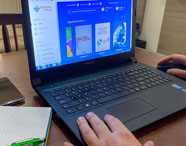 Pessoa acessando a biblioteca virtual da Faculdade de Letras Português em Presidente Prudente em um notebook, utilizando recursos digitais para pesquisa e estudo.