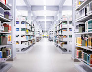 Corredor da biblioteca da Faculdade de Letras Português em Presidente Prudente, com prateleiras repletas de livros, em ambiente amplo e iluminado.