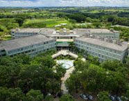 Vista aérea do campus da Faculdade de Celulose e Papel em Presidente Prudente, com edifícios modernos, áreas verdes e paisagismo, destacando a infraestrutura universitária.