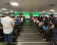 Auditório da Faculdade de Terapia Ocupacional em Guarujá com público em pé, participando de evento acadêmico ou formatura da Unoeste.