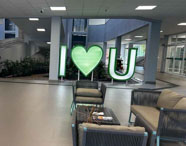 Áreas de convivência modernas da Faculdade de Estética e Cosmética em Guarujá, com sofás e o letreiro I LOVE U, promovendo o bem-estar dos alunos.