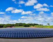 Ampla usina solar fotovoltaica no Campus 2 da Faculdade de Energias Renováveis, com céu azul e nuvens, simbolizando a produção de energia sustentável.