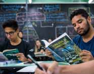 Faculdade de administração em Presidente Prudente, alunos analisando livros: estudantes sentados em sala de aula, consultam livros acadêmicos de administração e fazem anotações. O fundo traz quadro-negro com mapas mentais e conceitos, criando um clima de estudo intenso, foco e aprofundamento nos conteúdos essenciais para a formação do administrador.