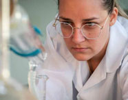 Aluna da Faculdade de Alimentos em laboratório, realizando experimentos e análises com equipamentos científicos, focando em pesquisa e qualidade alimentar.