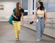 Alunas da Faculdade de Sistemas de Informação em Jaú caminhando e conversando em rampa do campus, representando a vida universitária.