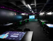 Sala Betha da Faculdade de Mídias Sociais Digitais, com mesas interativas e cadeiras modernas, preparada para aulas e projetos tecnológicos.