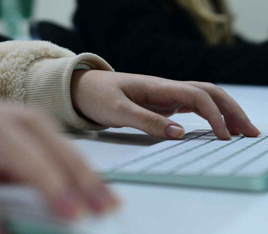Mãos digitando em teclado de computador, representando o perfil profissional do curso de Mídias Sociais Digitais em Presidente Prudente, focado em tecnologia e comunicação.