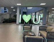 Áreas de convivência modernas da Faculdade de Ciências Biológicas em Guarujá, com sofás e o letreiro I LOVE U, promovendo o bem-estar dos alunos.