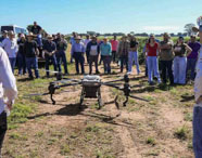 Demonstração de drone agrícola para estudantes e profissionais da Faculdade de Agronomia, mostrando tecnologia para pulverização e monitoramento de lavouras.