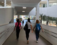 Alunas da Faculdade de Agronomia em Jaú caminhando por corredor interno do campus, com luz natural e ambiente moderno.