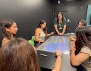 Alunos da Faculdade de Agronomia em Jaú em atividade na Sala Betha, utilizando mesas interativas para aprendizado colaborativo e tecnológico.