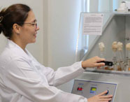Aluna da Faculdade de Medicina Veterinária realizando análise laboratorial com amostras em tubos de ensaio, utilizando equipamento de incubação.