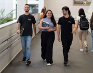 Alunos da Faculdade de Terapia Ocupacional em Jaú caminhando e interagindo em rampa do campus, representando a vida universitária e convivência.