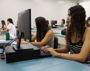 Alunos da Faculdade de Terapia Ocupacional em Jaú utilizando computadores em laboratório de informática, destacando o uso da tecnologia no aprendizado.