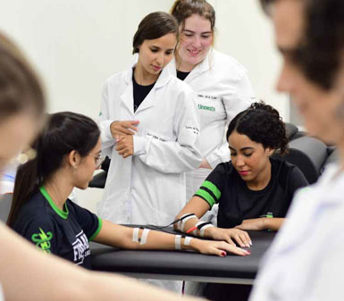 Alunas da Faculdade de Terapia Ocupacional em Jaú em aula prática com equipamentos de eletroterapia, representando o perfil profissional do curso em reabilitação.