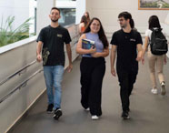 Alunos da Faculdade de Estética e Cosmética em Jaú caminhando e conversando em rampa do campus, representando a vida universitária.