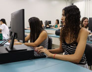 Alunos da Faculdade de Estética e Cosmética em Jaú em aula prática no laboratório de informática, utilizando computadores para atividades acadêmicas.