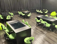 Sala Betha da Faculdade de Estética e Cosmética em Jaú, com mesas interativas e cadeiras modernas, para aulas e projetos tecnológicos.