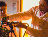 Alunos da Faculdade de Silvicultura em laboratório, analisando plantas com equipamentos de medição, focando em pesquisa e desenvolvimento vegetal.
