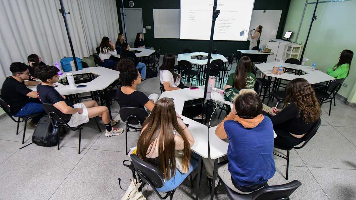 Alunos de Sistemas de Informação participam de aula com metodologias ativas, engajados em discussão e aprendizado colaborativo em sala de aula.