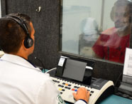 Aluno da Unoeste realizando prática de audiometria em cabine acústica, no curso de Fonoaudiologia. 