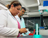 Aluna da Unoeste participando de simulação prática com equipamentos específicos de Engenharia Elétrica. 