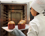Aluna utilizando forno industrial na disciplina prática da graduação em Gastronomia da Unoeste 