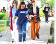 Grupo de estudantes da Faculdade de Gestão Ambiental caminhando em área verde do campus, interagindo e aproveitando o ambiente universitário.