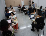 Alunos da Faculdade de Gestão Ambiental em Presidente Prudente utilizando computadores em sala de aula, aplicando conhecimentos em tecnologia e gestão.