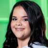 Imagem de Ana, aluna do curso de enfermagem no campus Presidente Prudente, usando um uniforme branco. O fundo da imagem é composto por uma parede verde vibrante, sugerindo um espaço moderno e acolhedor. A iluminação é suave, criando um contraste agradável entre o uniforme e o fundo colorido.