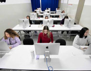 Vista geral do laboratório de iMacs com alunos em atividade no curso de Design Gráfico da Unoeste. 