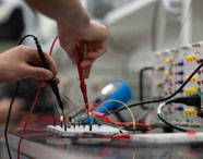 Estudante da Unoeste manuseando componentes eletrônicos durante atividade prática de Mecatrônica. 