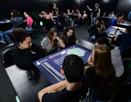 Estudantes da Unoeste participando de atividade interativa na sala Betha, utilizando tecnologia educacional avançada. 